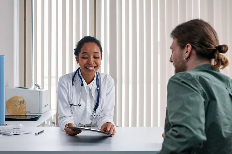 Dr. Kapoor reviewing a patient's records during a consultation